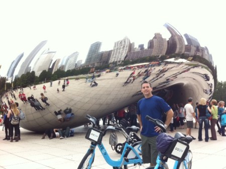 Blake pauses in front of Cloud Gate in Millennium Park, alongside his Divvy Bike.