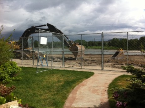 A digger scrapes up the last of the asphalt in preparation for road resurfacing.