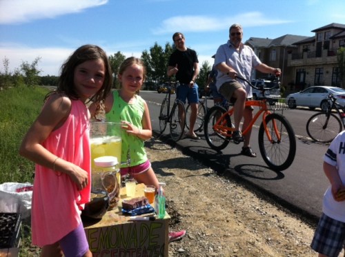 Cyclists line up for a cup of lemonade along the Bow River pathway in Inglewood on the weekend.