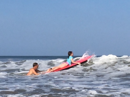 Rob pushes Avery out into the surf.